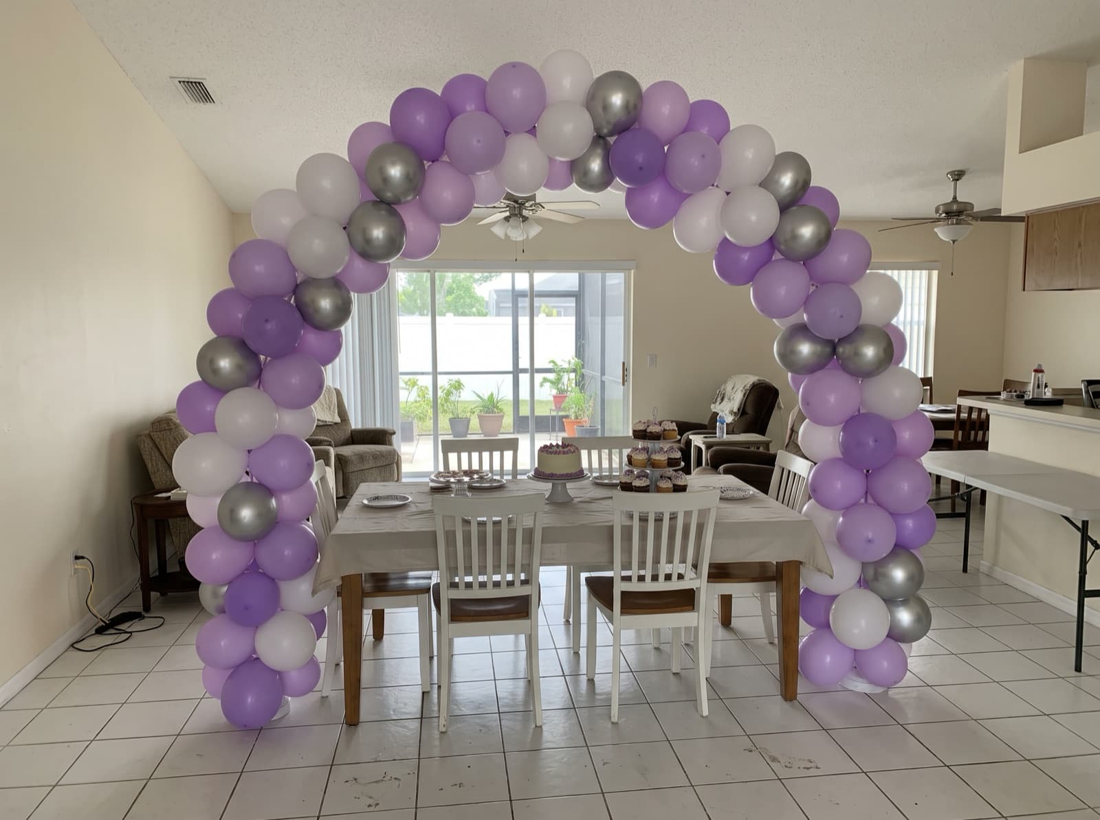 Organic balloon arch in lavender, lilac and silver over a dessert table