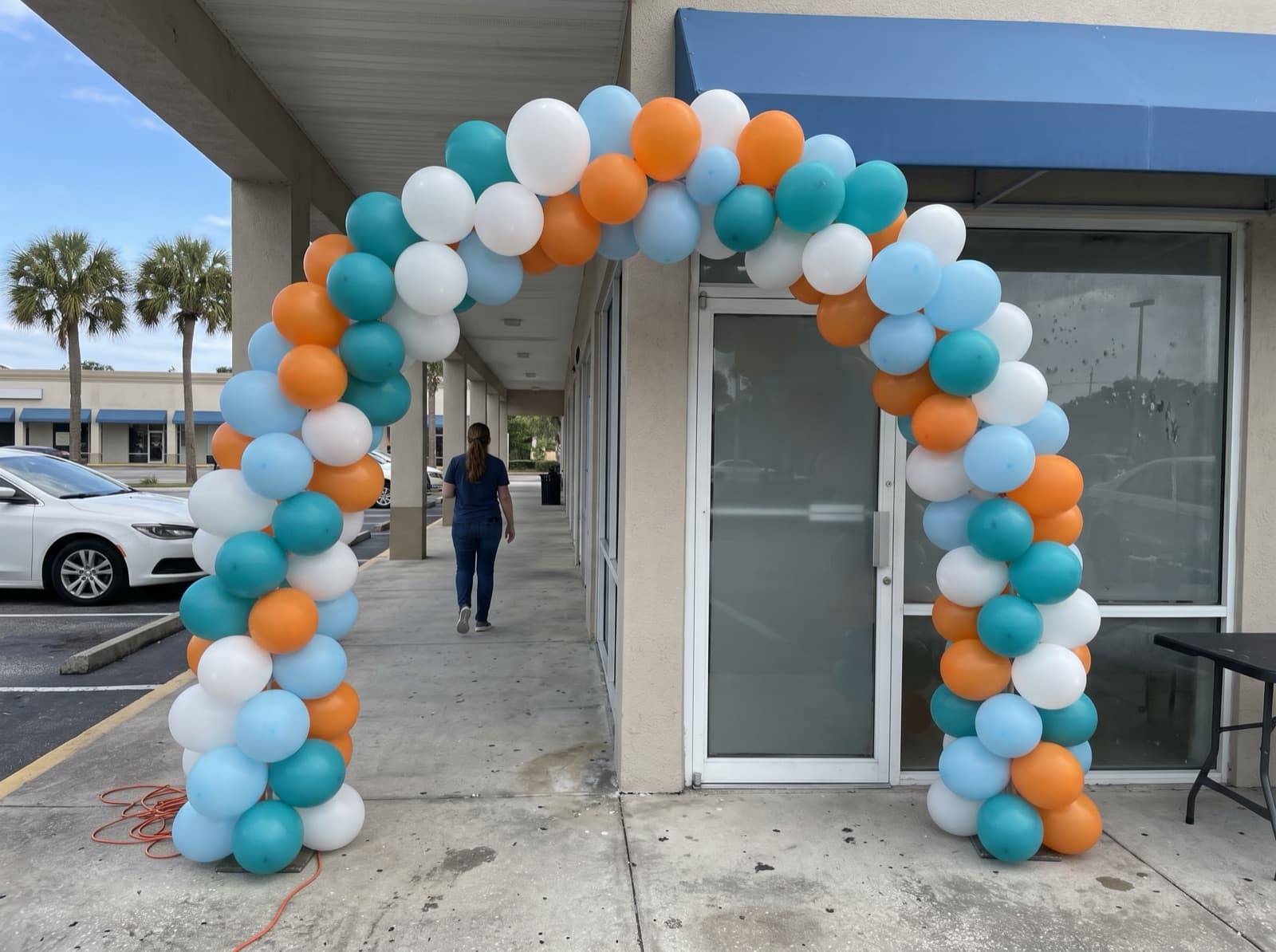 Large balloon arch over a shopping-center storefront